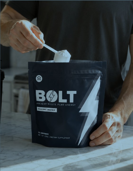 Scooping BOLT Energy Drink Mix powder from the Electric Orange pouch